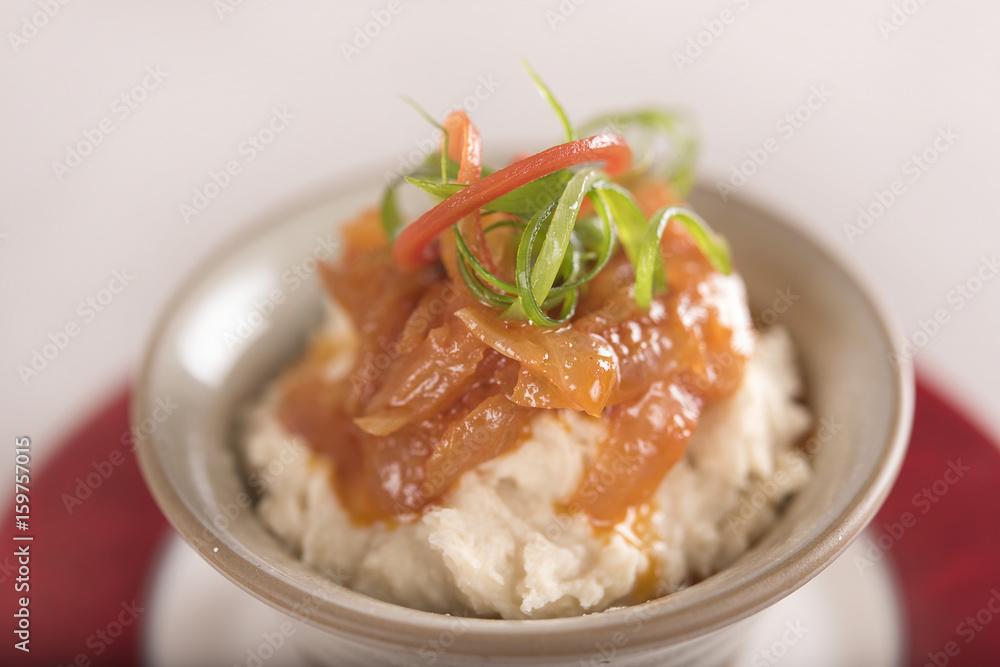 Beans puree with sweet onion and tomato sauce, served in a bowl on a red and white plate, decorated with herbs, light background, isolated Beans puree with sweet onion and tomato sauce, served in a bowl on a red and white plate, decorated with herbs, light background, isolated