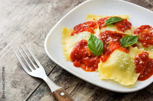 Ravioli with tomato sauce and basil on wooden table  