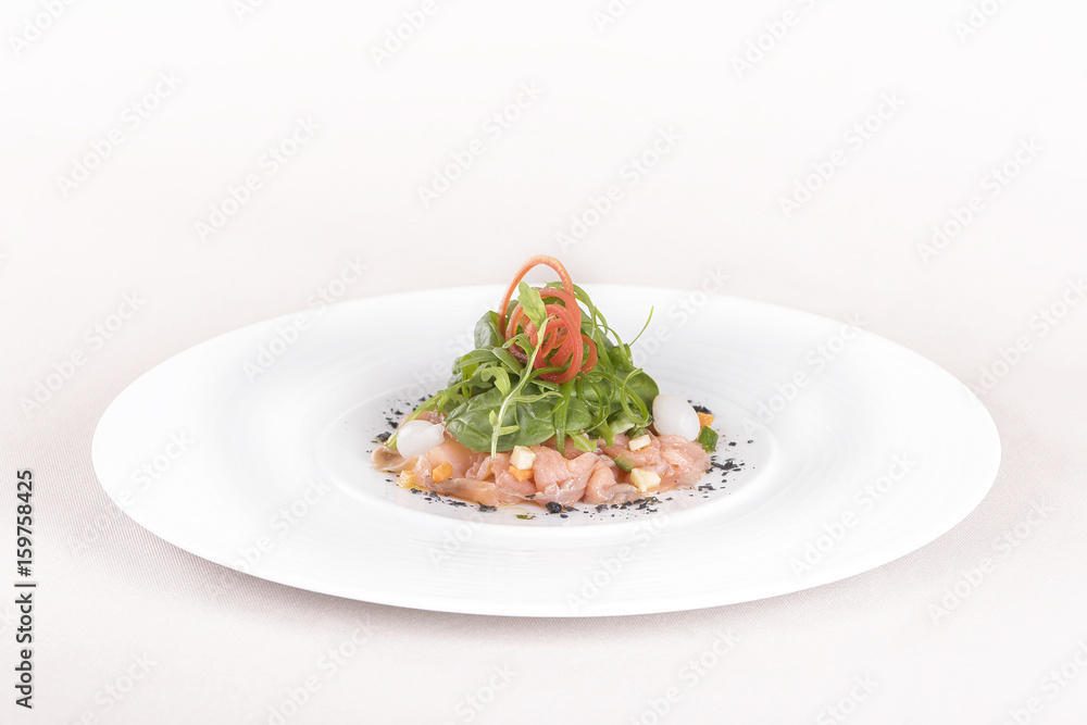Fresh smoked salmon salad, served with rucola and baby spinach and pieces of vegetables, decorated with herbs, placed on white plate, light background, isolated Fresh smoked salmon salad, served with rucola and baby spinach and pieces of vegetables, decorated with herbs, placed on white plate, light background, isolated