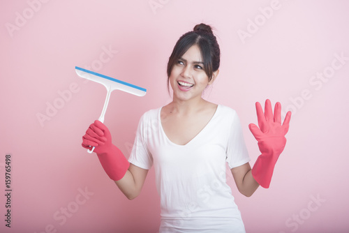 Beautiful asian housewife smiling on pink background