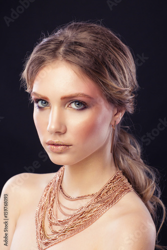 Fashion portrait model girl, with a many golden chains