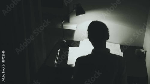 Young woman works in the dark room. Horror atmosphere with camera sneak up.