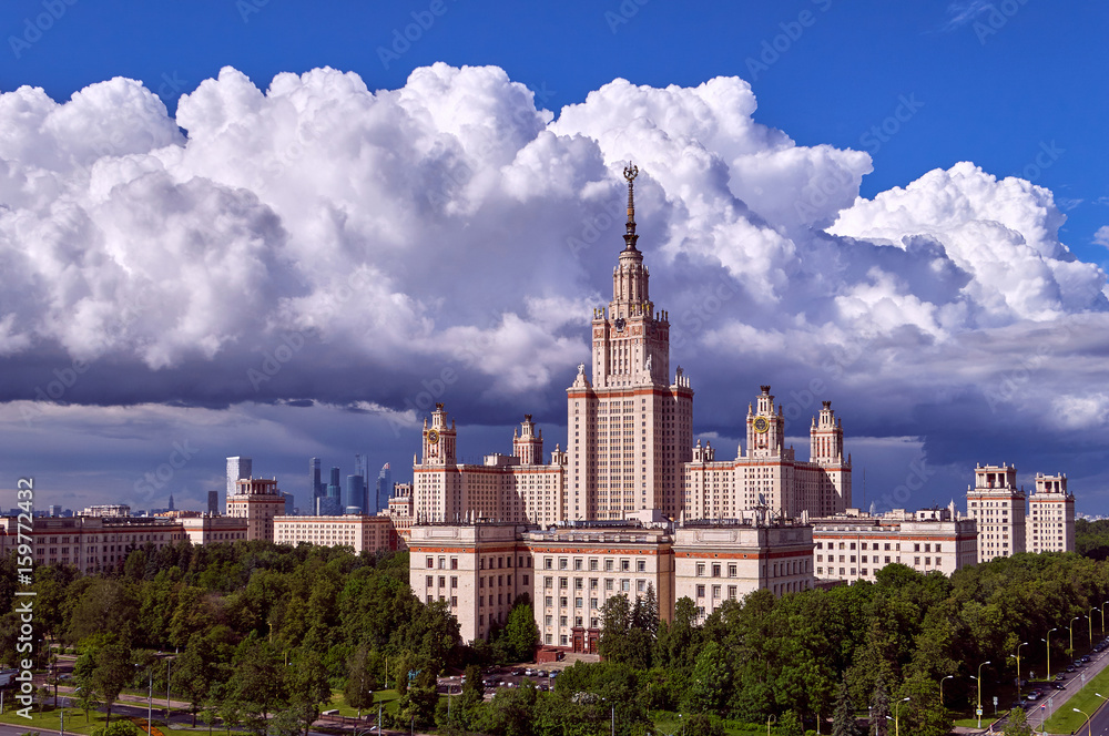 A landscape view of rainy clouds over the sunny spring campus of Lomonosov Moscow State University under blue sky