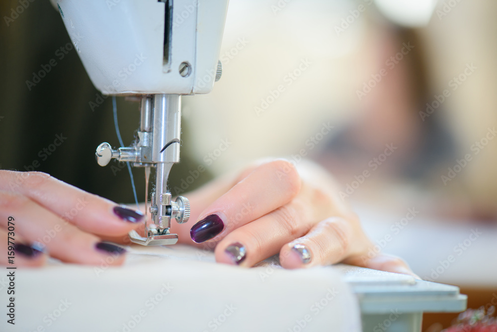 womens hands with sewing machine