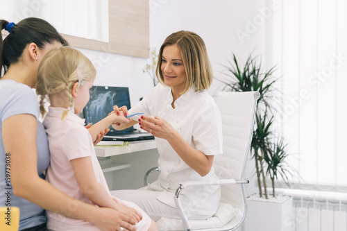 Best way to keep you teeth healthy. Mother and daughter at the dentist office. Dentist showing how to brush teeth.