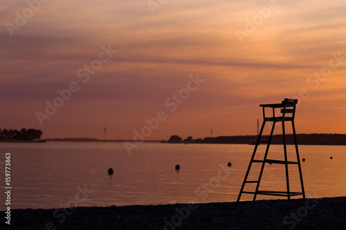 Rescue tower on a river beach against a summer sunset