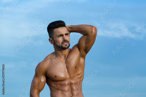 model man with muscular body on blue sky