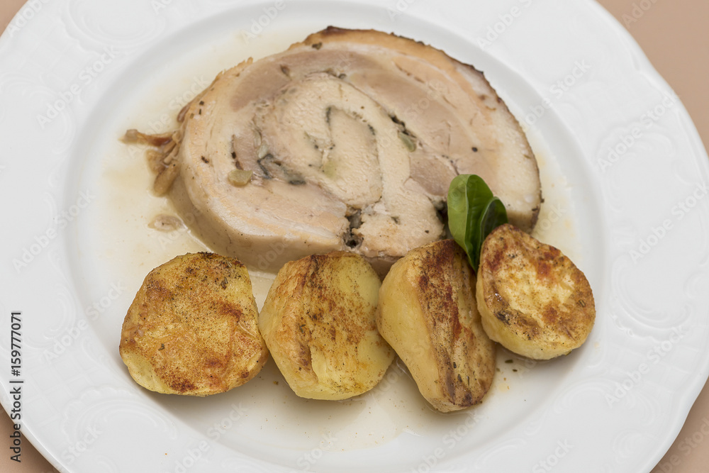 Slice roasted pork, served with potatoes and decorated with herbs, placed on white plate, light background, isolated Slice roasted pork, served with potatoes and decorated with herbs, placed on white plate, light background, isolated