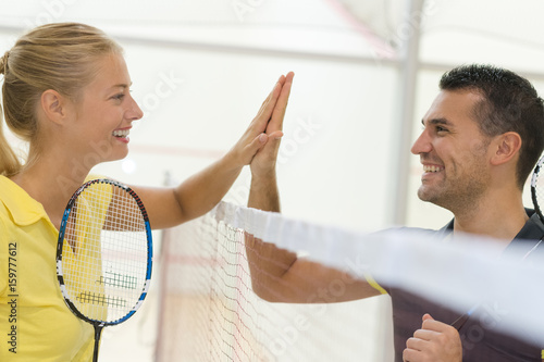 Fotografía couple doing high five after badminton match