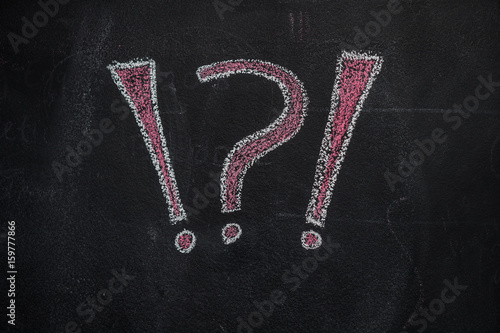 White and red question and exclamation marks drawn with chalk on blackboard photo