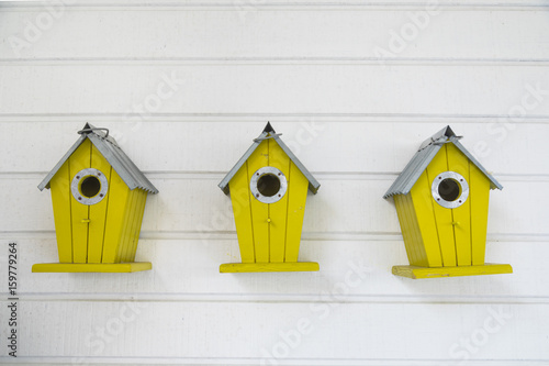 Canvas Print Small wooden birdhouse hanging outdoors in backyard.