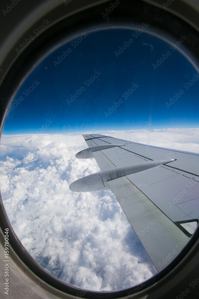 View from airplane window with blue sky and white clouds View from airplane window with blue sky and white clouds