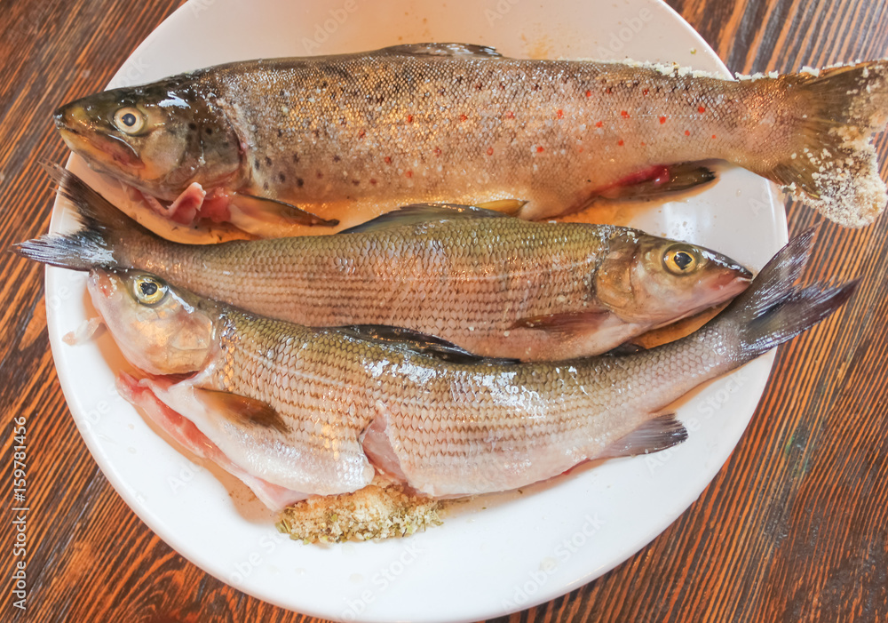 fresh fish on the plate, cooked for frying. Fresh wild trout and grayling on the plate.. fresh fish on the plate, cooked for frying. Fresh wild trout and grayling on the plate..