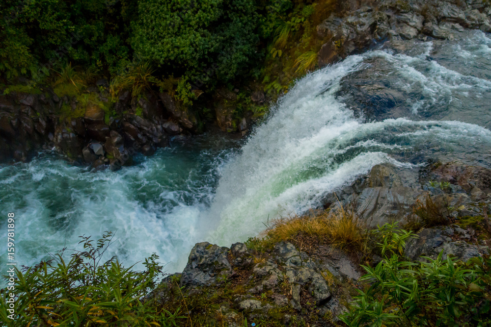Fototapeta premium Water from volcano Mt Ruapehu forms Tawhai Falls in Tongariro National Park, New Zealand, lateral view