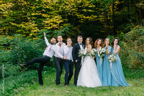 Guests at the wedding send an air kiss to the camera in nature in summer