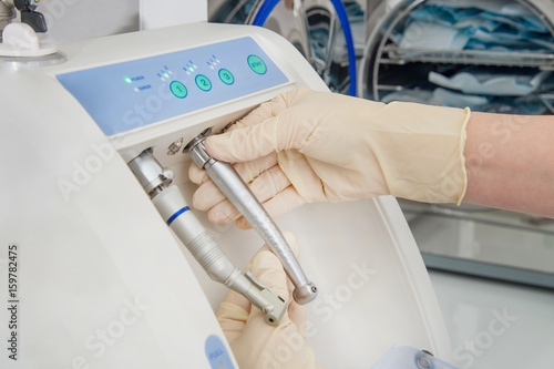 Instrument sterilization and cleaning in dentistry, using automatic instrument maintenance equipment to clean turbines and handpieces, closeup shoot.