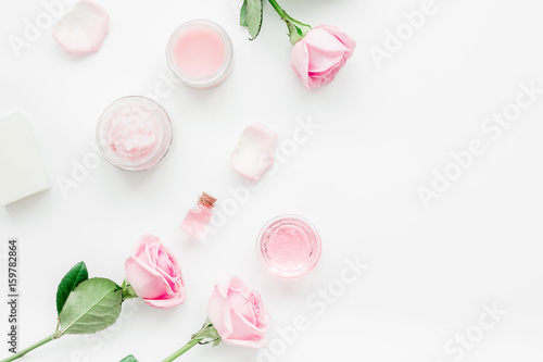 rose organic cosmetics with salt, cream and oil on white table background top view