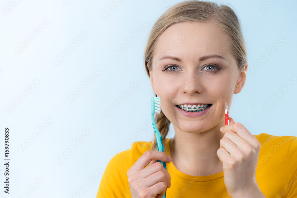 Woman smiling cleaning teeth with braces Woman smiling cleaning teeth with braces