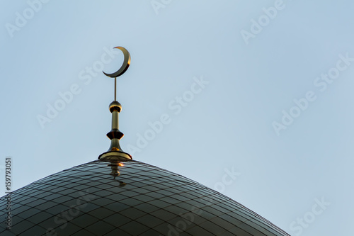 Minaret with a crescent of the Moslem mosque at sunset.