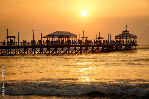 Sunset at pier of Huanchaco town, Peru photo