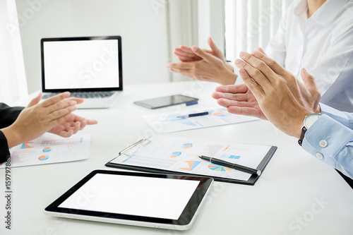 business seminar listeners clapping hands with documents having discussion in office