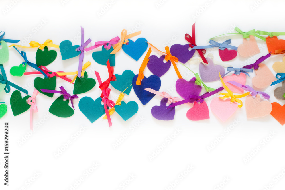 Bright colored hearts made of felt. White background.