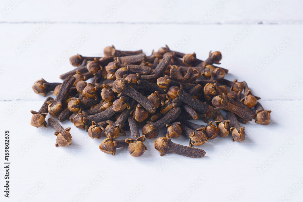 Fototapeta premium Cloves on white wooden table in the background.