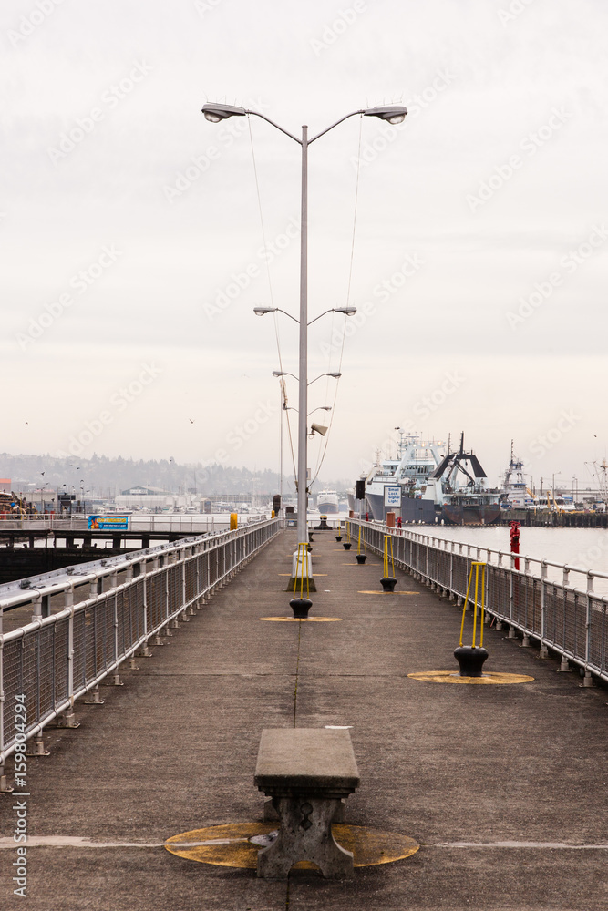 Lightpoles on a dock with boats in the distance