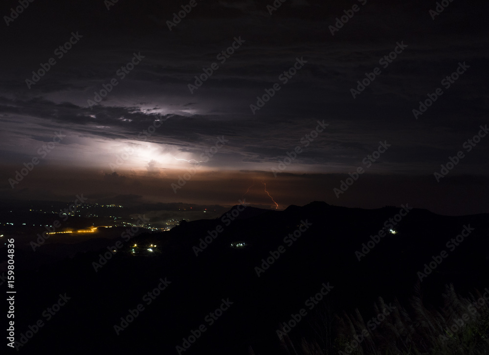Rain clouds and Thunderstorm lightning bolt with city lights at night. Rain clouds and Thunderstorm lightning bolt with city lights at night.