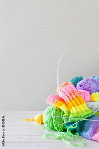 Closeup of basket with colorful yarn clews. Knitted Socks.