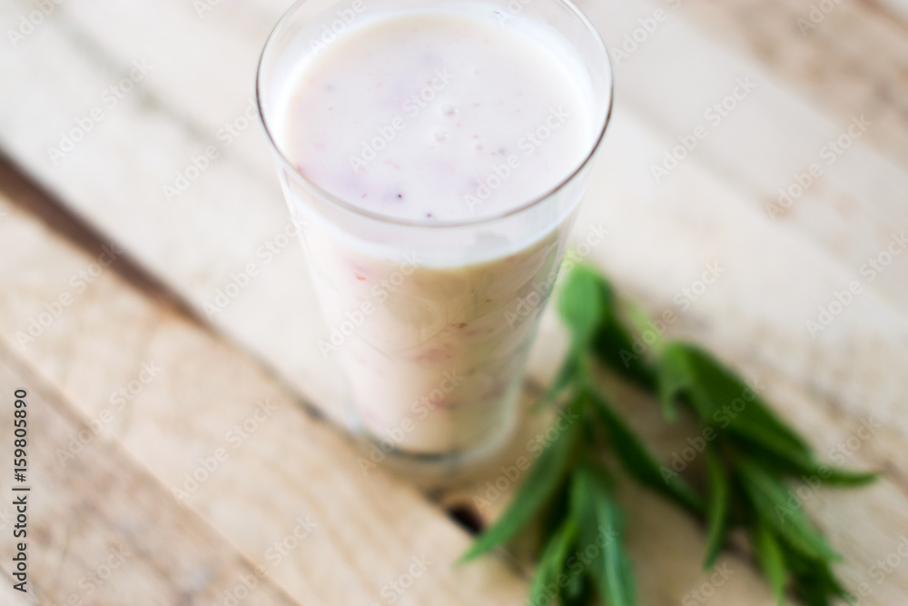 Milk shake yogurt with strawberry slices on a wooden background. Milk shake yogurt with strawberry slices on a wooden background.