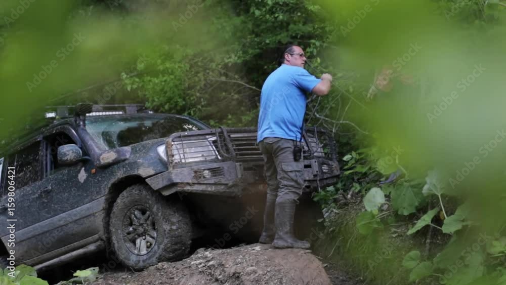 Expeditionary SUV trying overcom dangerous complex terrain at forest via winch. Expeditionary SUV trying overcom dangerous complex terrain at forest via winch.