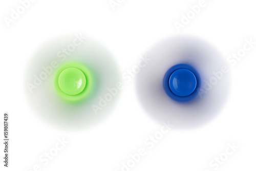 Green and blue toy fidget spinner spinning isolated on white background