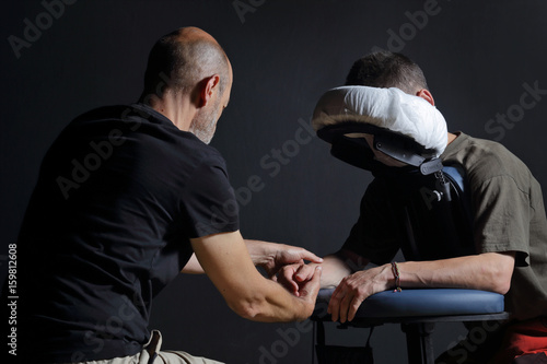 Fotografie homme pratiquant massage shiatsu assis sur une chaise