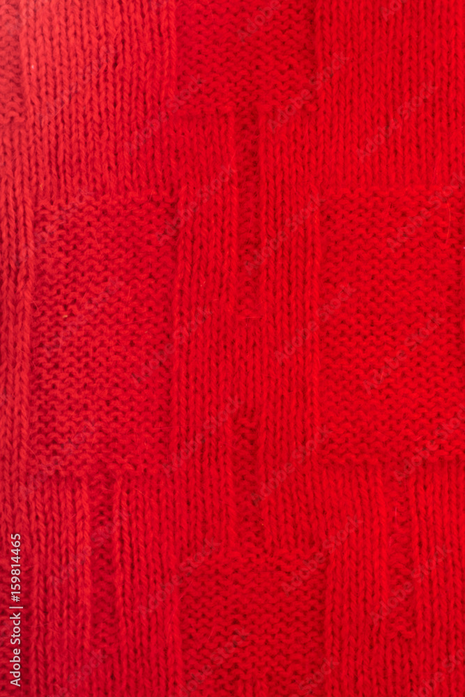 Sweater or scarf fabric texture large knitting. Knitted jersey background with a relief pattern. Braids in knitting . Wool hand- machine, handmade, red. Sweater or scarf fabric texture large knitting. Knitted jersey background with a relief pattern. Braids in knitting . Wool hand- machine, handmade, red.