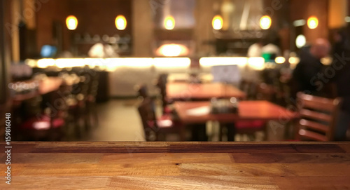 Empty wooden table top with blurred restaurant on background