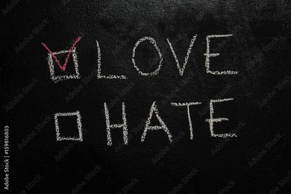 Love or Hate written with white chalk on blackboard Love or Hate written with white chalk on blackboard