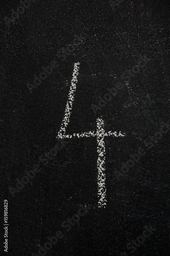 Number 4, four drawn with white chalk on blackboard. Education, school concept