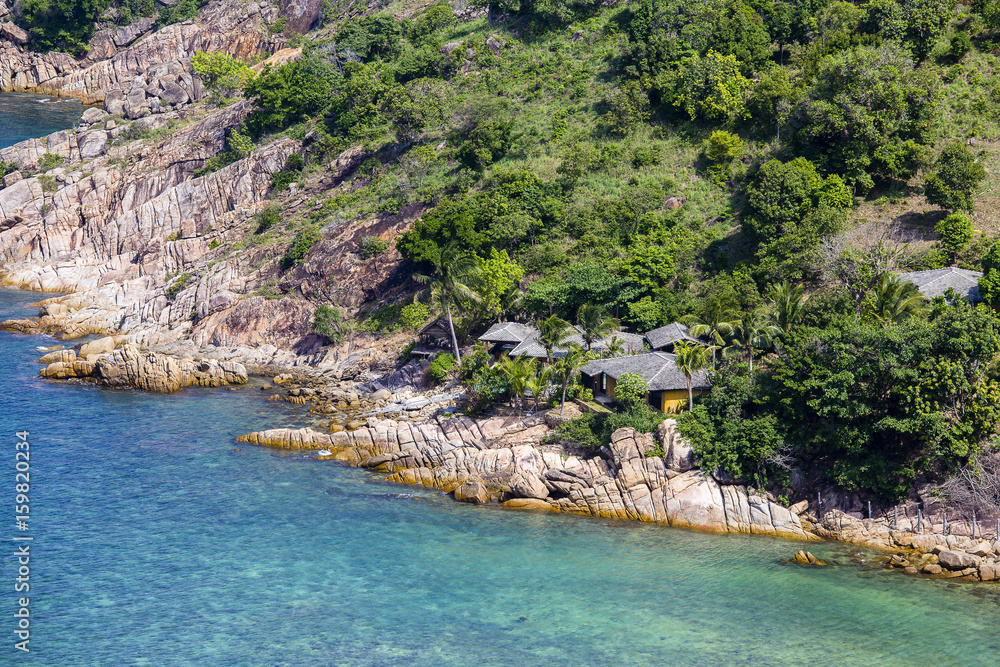 Tropical bungalow on a rocky beach next to the sea. Koh Phangan Island, Thailand