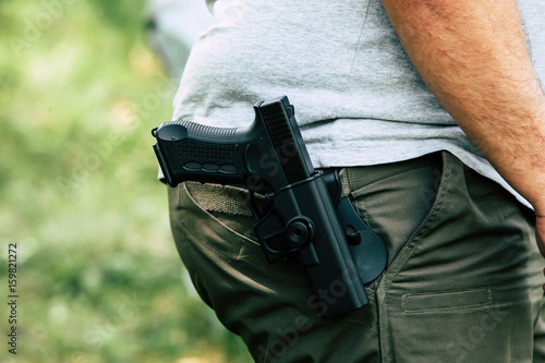 Pistol in the holster. The shooter trains. Is preparing to shoot at the target