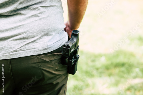 Pistol in the holster. The shooter trains. Is preparing to shoot at the target