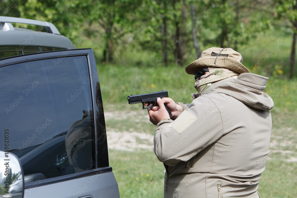 Man with a gun opens the car door Man with a gun opens the car door