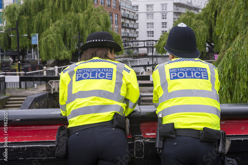 Two Metropolitan Police Officers in high-visibility jackets keep watch over Camden Lock in London. UK on election day  photo