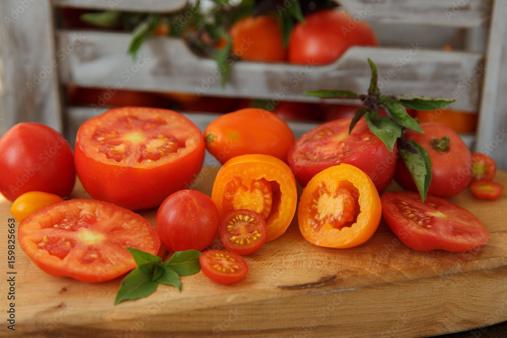 Tomatoes and basil on a wooden board in a rustic style Tomatoes and basil on a wooden board in a rustic style