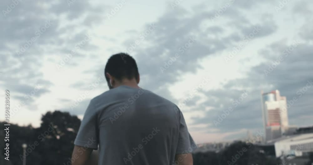 Caucasian male jogging in the city, urban background. 4K UHD RAW edited footage
