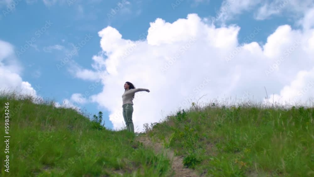 Woman on green spring winded hill, beautiful cloudy sky Woman on green spring winded hill, beautiful cloudy sky