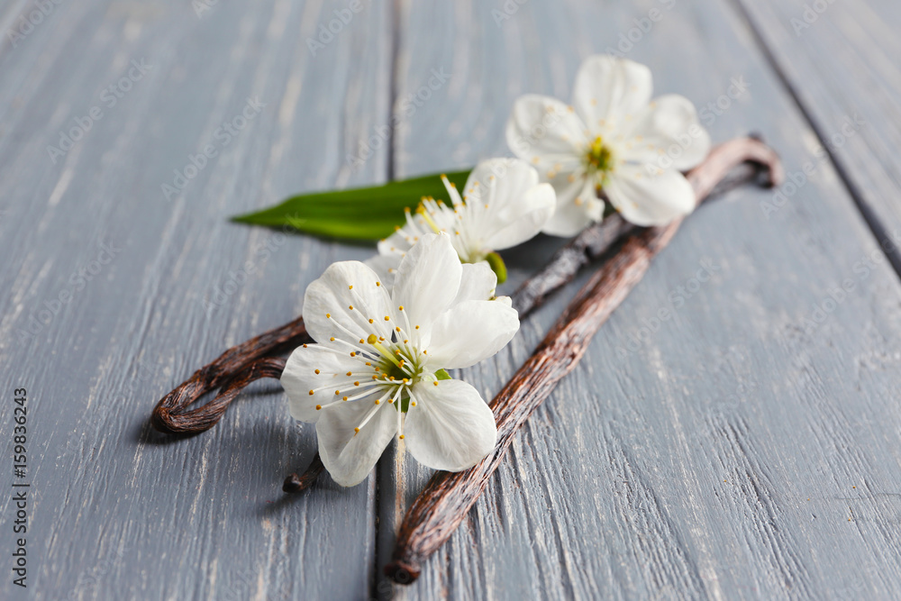 Dried vanilla sticks and flowers on wooden background, closeup Dried vanilla sticks and flowers on wooden background, closeup