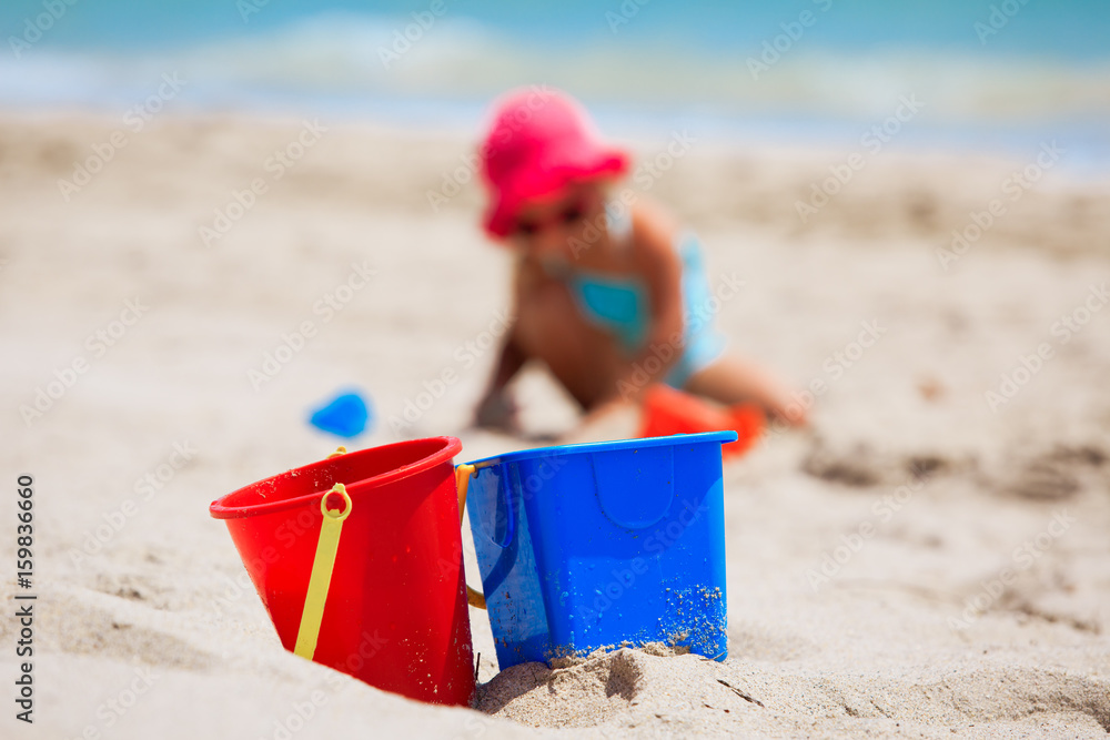kids toys and little girl play with sand on beach kids toys and little girl play with sand on beach