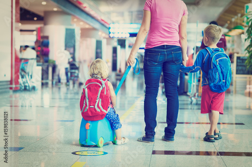 mother and two kids walking in airport