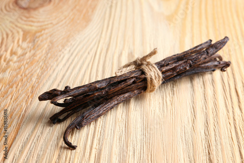 Dried vanilla sticks on wooden background, closeup
